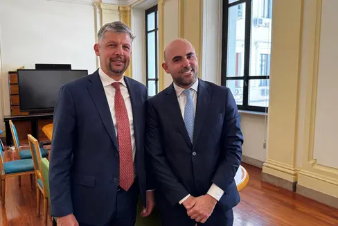 Alfreider (a man ciampa) cun le sotsecreter de Stat al Minister dles Infrastrotöres y Trasporc (MIT), Tullio Ferrante. (Retrat: USP/Departimënt Infrastrotöres y Mobilité)