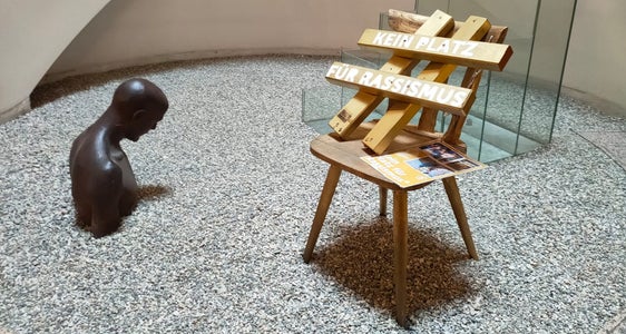 Ein goldener Stuhl mit der Botschaft Kein Platz für Rassismus ist seit heute im Eingangsbereich der deutschen Landeskulturabteilung ausgestellt. (Foto: LPA/Landesamt für Jugendarbeit)