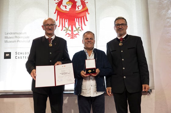 Karl Telser (al centro) di Silandro/Corces è stato premiato per il suo impegno nel fornire aiuto silenzioso alle persone bisognose oltre i confini della provincia. Nella foto con lui: i presidenti Anton Mattle (a sinistra) e Arno Kompatscher. (Foto: Land Tirol/Sedlak)