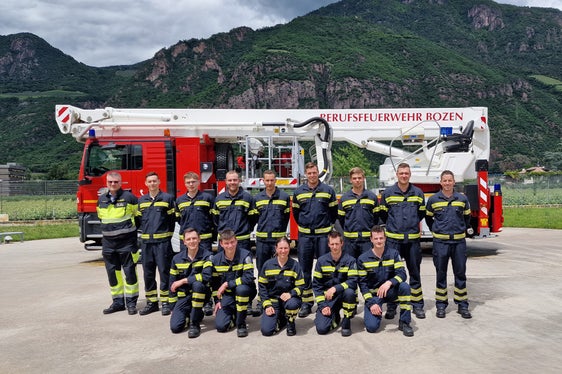 Offizielles Gruppenbild mit Kommandant Florian Alber (stehend, ganz links) zum Abschluss des elften Ausbildungskurses zum Feuerwehrmann beziehungsweise zur Feuerwehrfrau (Foto: LPA/Berufsfeuerwehr Bozen)