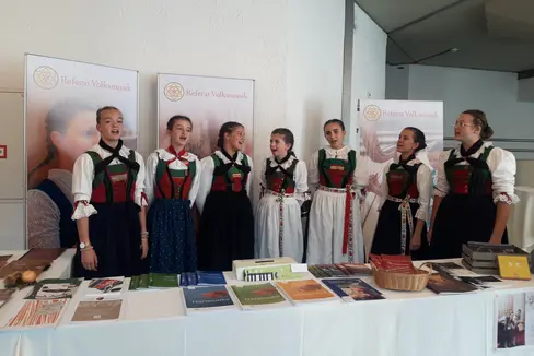 La Sezione musica popolare della Direzione provinciale Scuola musicale tedesca e ladina era presente con un proprio stand alla fiera internazionale di Innsbruck, punto d’incontro per i gruppi altoatesini, i loro insegnanti, amici e familiari. Nella foto, il gruppo Nos Ladines durante l’esibizione canora. (Foto: USP/Sezione musica popolare della Direzione provinciale Scuola musicale tedesca e ladina)
