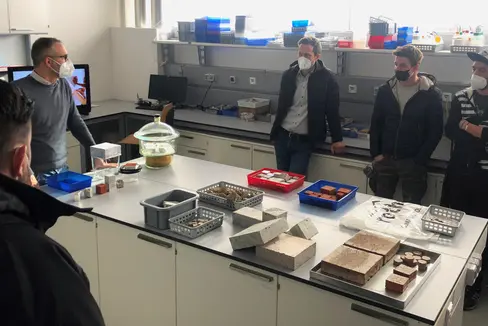 Apprendisti muratori nel laboratorio di prove igrotermiche dell'Eurac con il ricercatore senior Marco Larcher (Foto: ASP/Lvh-Apa)