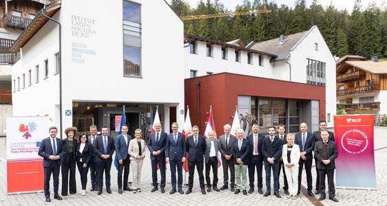 Gruppenfoto der Euregio-Versammlung mit weiteren Ehrengästen und Führungskräften vor dem Istitut ladin Micurà de Rü in St. Martin in Thurn im Gadertal: Mit dem EuregioFamilyPass die vergünstigten Vorteile für Familien weiter stärken. (Foto: LPA/Tiberio Sorvillo)