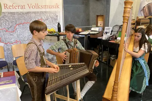 Die Tuftwegmusi (Hannes, Lukas und Lea Niederfriniger) hat neben ihren Auftritten beim Wettbewerb und in Innsbrucks Innenstadt auch Zeit gefunden, am Infostand des Referates Volksmusik aufzuspielen. (Foto: Referat Volksmusik)