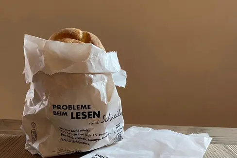 Probleme beim Lesen und Schreiben? Du bist nicht allein! Das betrifft fast jede zehnte Person. Wir unterstützen; anonym, kostenlos steht auf den Brotsäckchen, die ab dem Welttag der Muttersprache am 21. Februar in vielen Bäckereien im Vinschgau benutzt werden. (Foto: LPA/Amt für Weiterbildung/Astrid Crepaz)