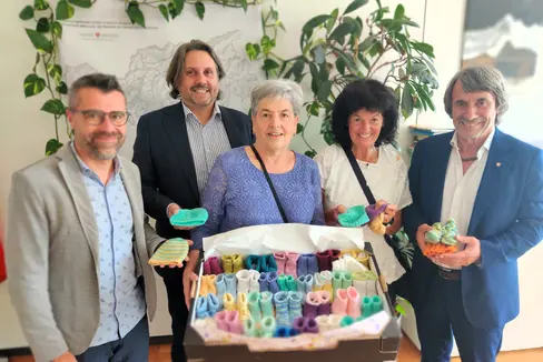 Piccolissimi e lavorati a maglia con tanto amore: l'assessore provinciale alla Prevenzione sanitaria e salute Hubert Messner (a destra), il coordinatore infermieristico Daniele Gianotti (a sinistra), il primario Alex Staffler (2° a sinistra) hanno ricevuto nel reparto di neonatologia di Bolzano dei vestitini fatti a mano per i bimbi nati prematuri da Regina Marth (al centro, da sinistra) e Irene Borek. (Foto: USP/ Dipartimento Prevenzione sanitaria e salute)