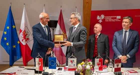 Mudamënt danter Südtirol y Tirol: coche simbol per la presidënza dl’Euregio ti sëurandà l presidënt dla Jonta provinziela de Bulsan Arno Kompatscher, segondo da man ciancia, al capitan dl Tirol Anton Mattle, a man ciancia, la tle storica dla Cësa Waag, sënta dl’Euregio a Bulsan. (Foto: USP/Daniel von Johnston)