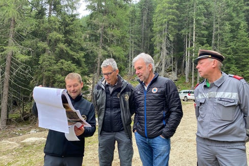 Der Projektant und Bauleiter vom Forstinspektorat Sterzing, Stefan Feichter, zeigt Forstinspektor Günther Unterthiner, Landesrat Arnold Schuler und dem Bezirksfeuerwehrinspektor von Brixen konrad Unterthiner die Pläne der Arbeiten. (Foto: LPA/Noemi Prinoth)