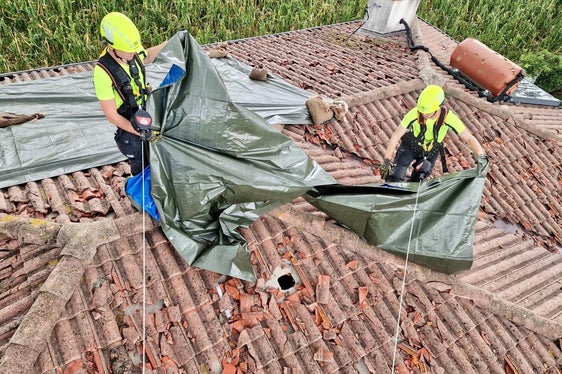 I vigili del fuoco altoatesini in azione sul tetto di un caseggiato colpito dal nubifragio. (Foto: ASP/Vigili del fuoco volontari dell'Alto Adige)