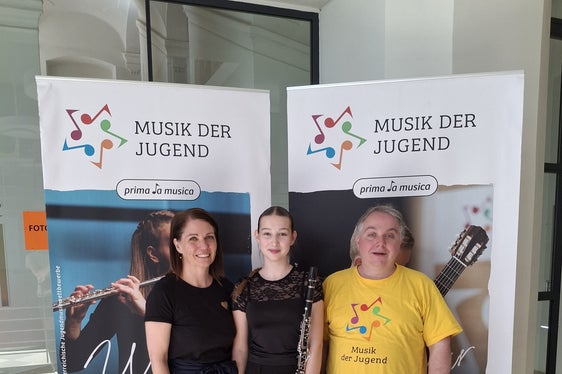 Linda Demattio (al centro) della scuola di musica Bassa Atesina con il suo clarinetto e la sua insegnante Uta Praxmarer (a sinistra) e l'accompagnatore al pianoforte Andreas Benedikter. (Foto: USP)