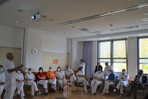 Bei der Präsentation im Rahmen des Lokalaugenscheins von Landeshauptmann Kompatscher wurden am Krankenhaus Schlanders aktuelle Zahlen und Informationen von Dr. Rainer, ärztlicher Leiter am Krankenhaus Schlanders (stehend, links im Bild) vorgestellt. (Foto: LPA)