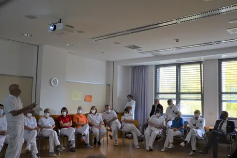 Bei der Präsentation im Rahmen des Lokalaugenscheins von Landeshauptmann Kompatscher wurden am Krankenhaus Schlanders aktuelle Zahlen und Informationen von Dr. Rainer, ärztlicher Leiter am Krankenhaus Schlanders (stehend, links im Bild) vorgestellt. (Foto: LPA)