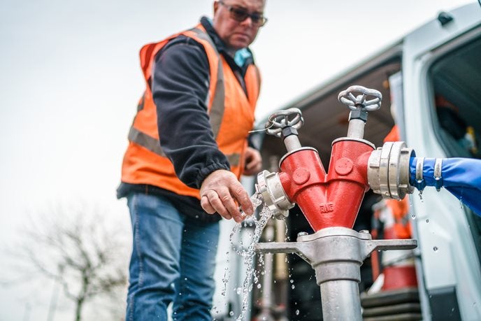 Evides werknemer in veiligheidskleding bij kraan