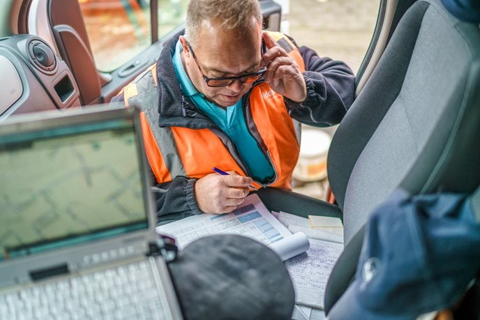 Man aan het bellen in oranje hesje