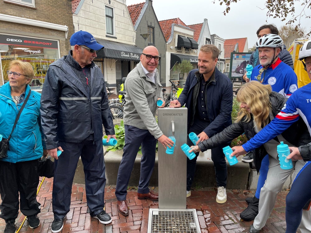 Erik ter Velde en Martijn Hamerslag tappen water in Evides-bidons voor de passerende wielerploeg ‘Tourclub Voorne Putten’. 