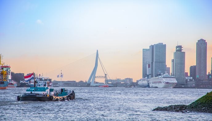 Drinkwaterboot vaart door Rotterdam met de  Erasmusbrug op de achtergrond