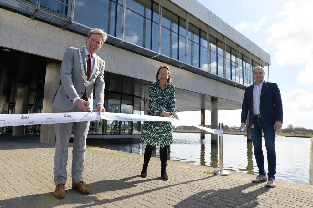 Burgemeester Foort van Oosten, algemeen directeur Annette Ottolini en regiohoofd Groot-Berenplaat Paul van Versendaal knippen het lintje tijdens de opening van productielocatie Berenplaat.