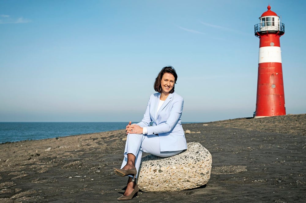 Vrouw op het strand bij een vuurtoren