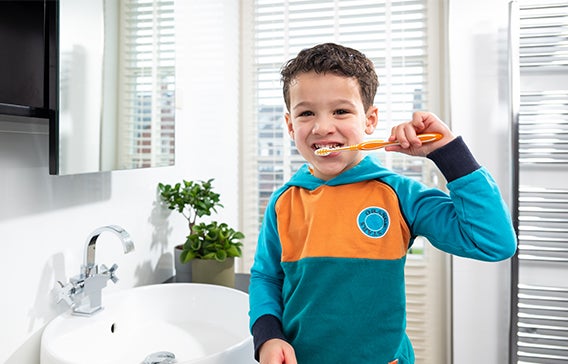 Jongen met tandenborstel in badkamer