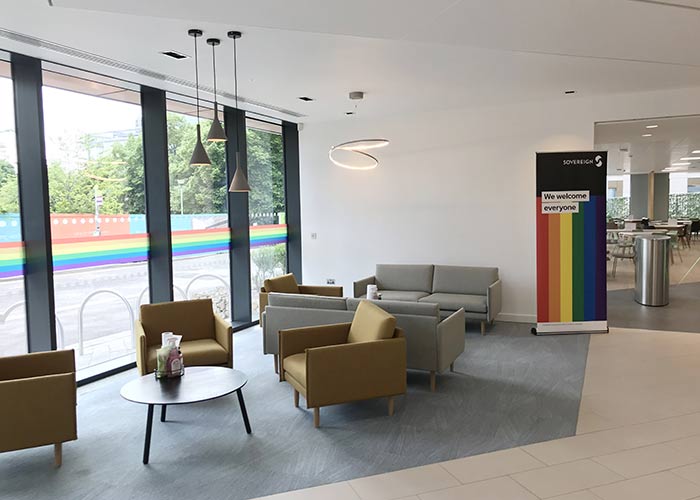 Table and chairs by an office window with the Pride banner