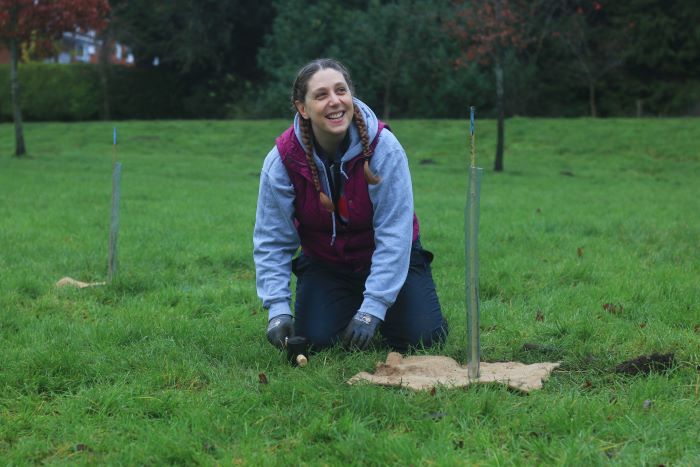 A woman planting a tree in the Lockdown Woods near Newbury