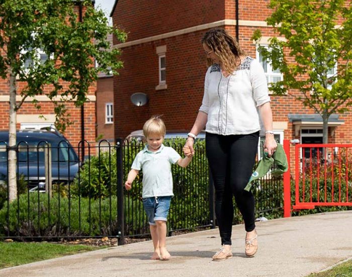 Mother and son walking through park