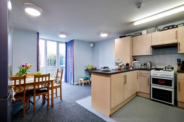 Example of kitchen in shared flat. Open plan kitchen which extends into a dining/lounge area with table and chairs (some items included for marketing purposes only). 