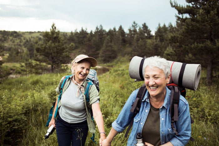 An older couple hiking through a field