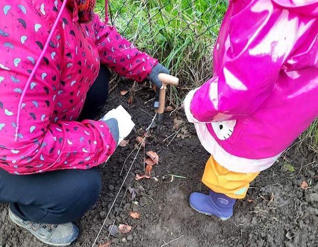 An adult and child planting seeds