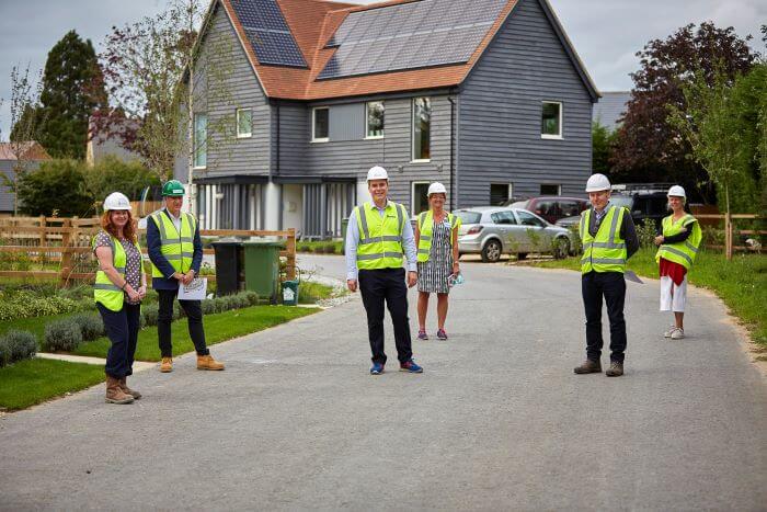 MP David Johnston stands in front of new carbon-zero homes near Abingdon