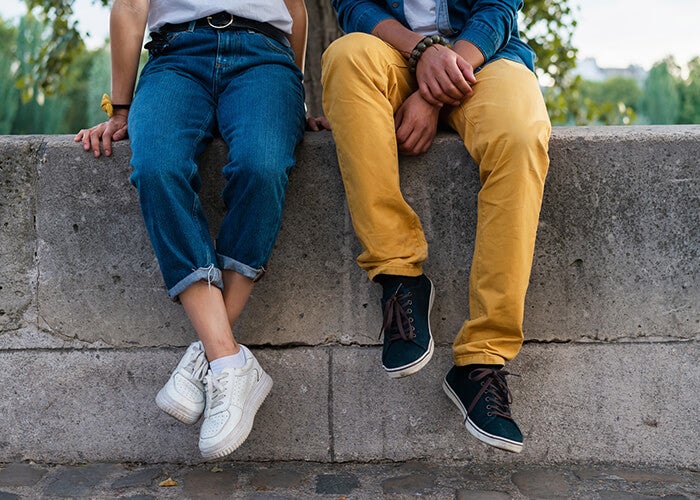 A close up of two people siting on a wall