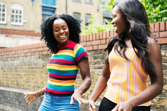 Two young women dancing outside