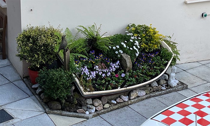 A canoe filled with pretty plants and flowers