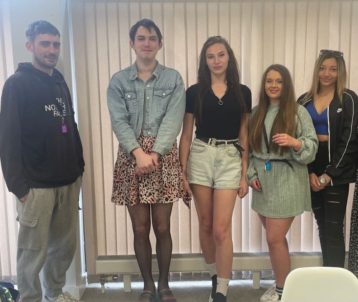 Group of young people standing in a line and posing for the camera