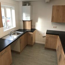 Completed kitchen project with wooden effect units and black surfaces