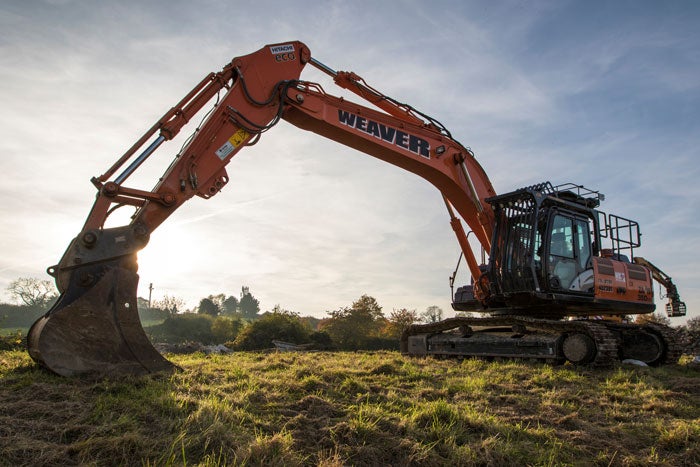 A large digger breaking ground in a field