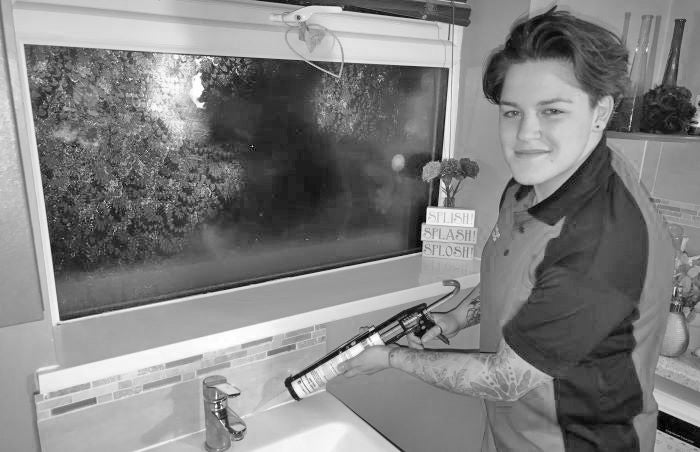 apprentice plumber tiling in a bathroom