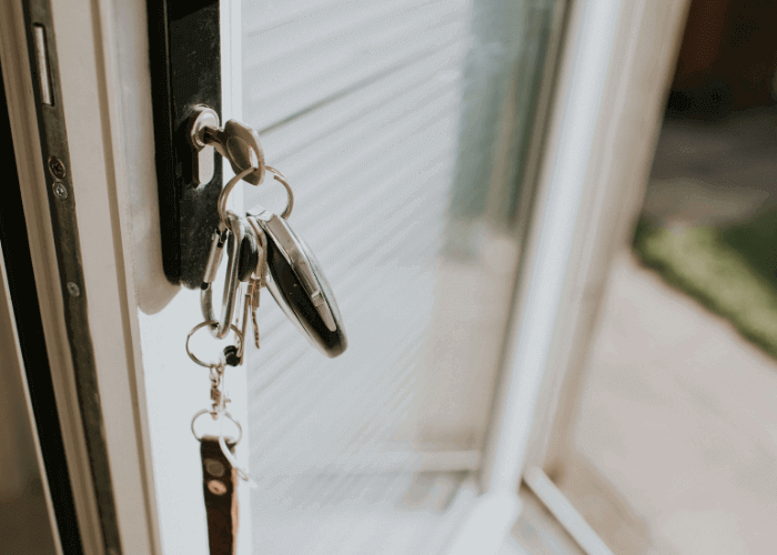 An open door with a set of keys in the lock