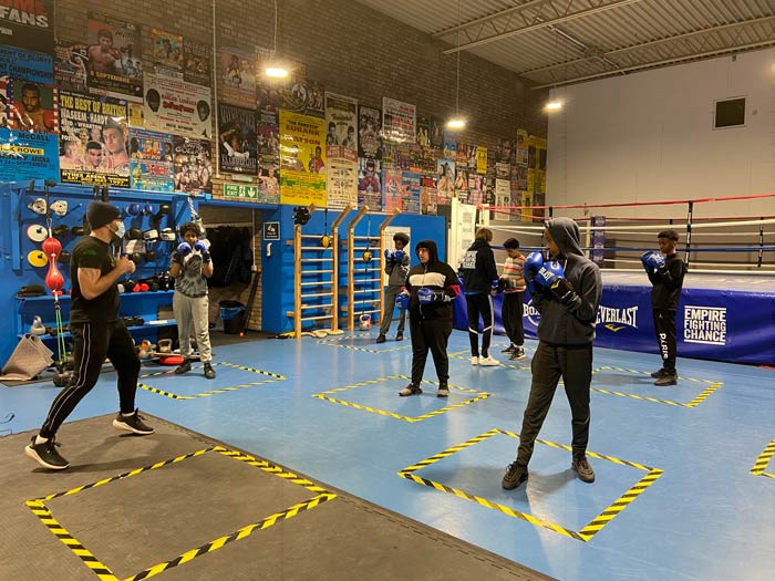 A group of teenagers attending a boxing class in a boxing gym