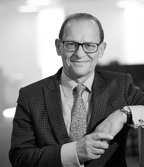 Black and white image of a smartly dressed man smiling at the camera