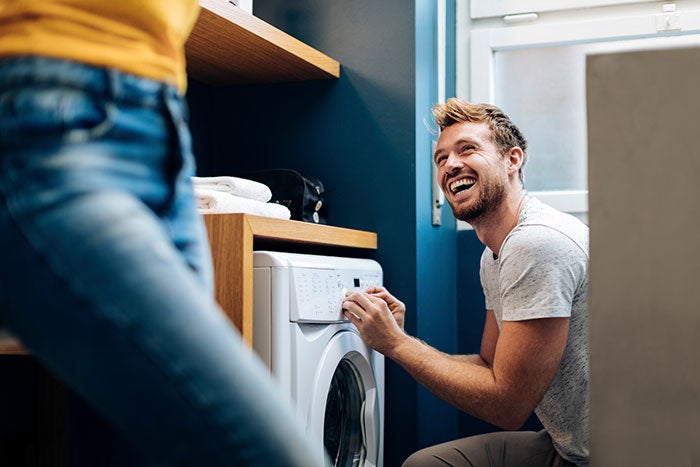 Man kneeling by a washing machine