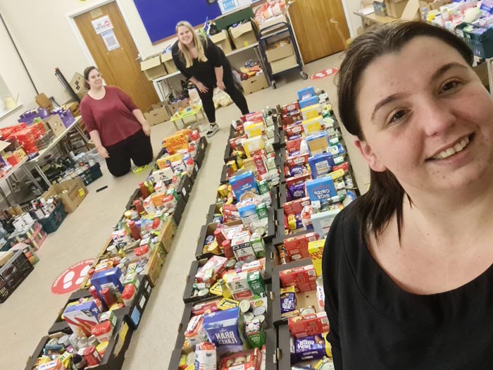 a team of people standing with rows of food boxes prepared for distribution in Bristol