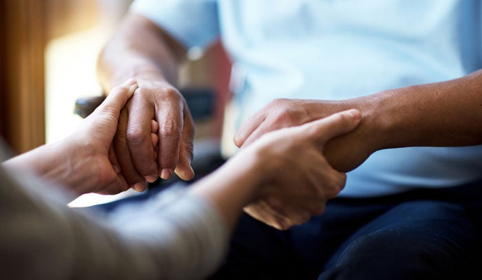 a close up of two people holding hands