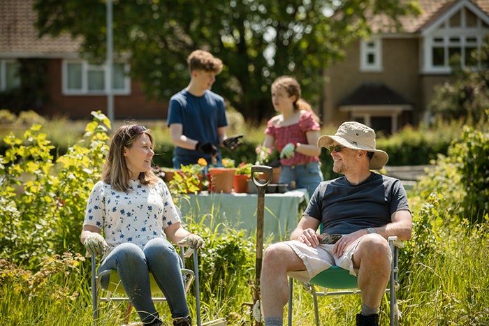 A mum, dad, son and daughter in their garden on a sunny day