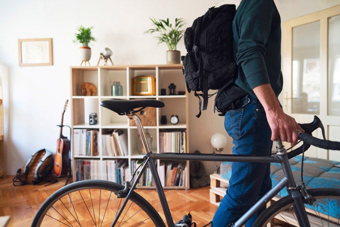 A person holding a bicycle in a flat