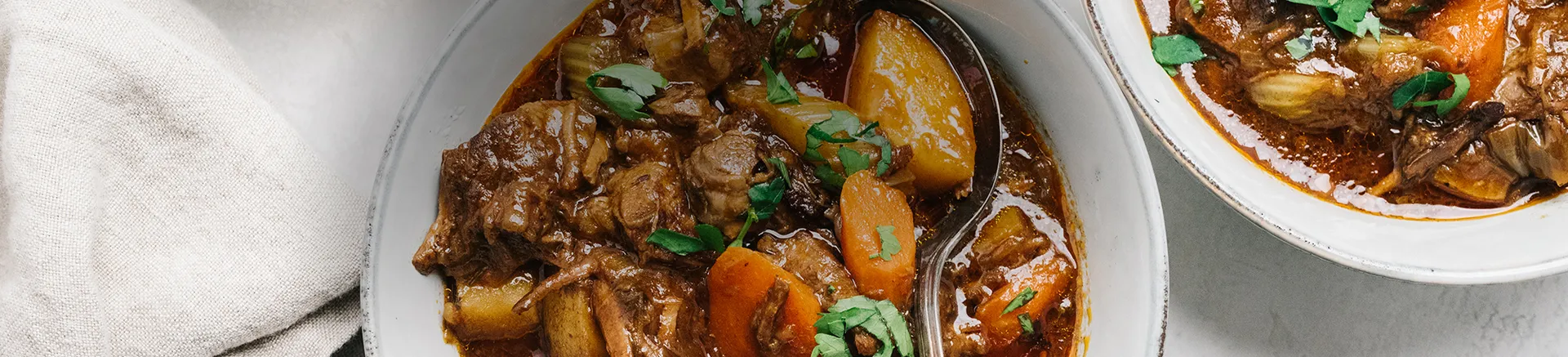 Zwei Teller Eintopf mit Fleisch und Karotten