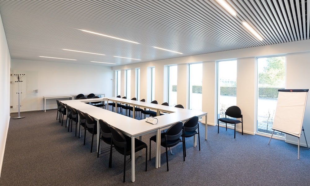 Een kamer met een lange tafel en stoelen