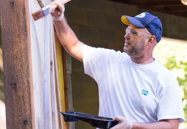 PPG volunteer painting exterior wall in Mount Gilead, Ohio 