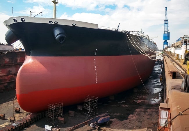 A large ship in a dock with Seawise Giant in the background