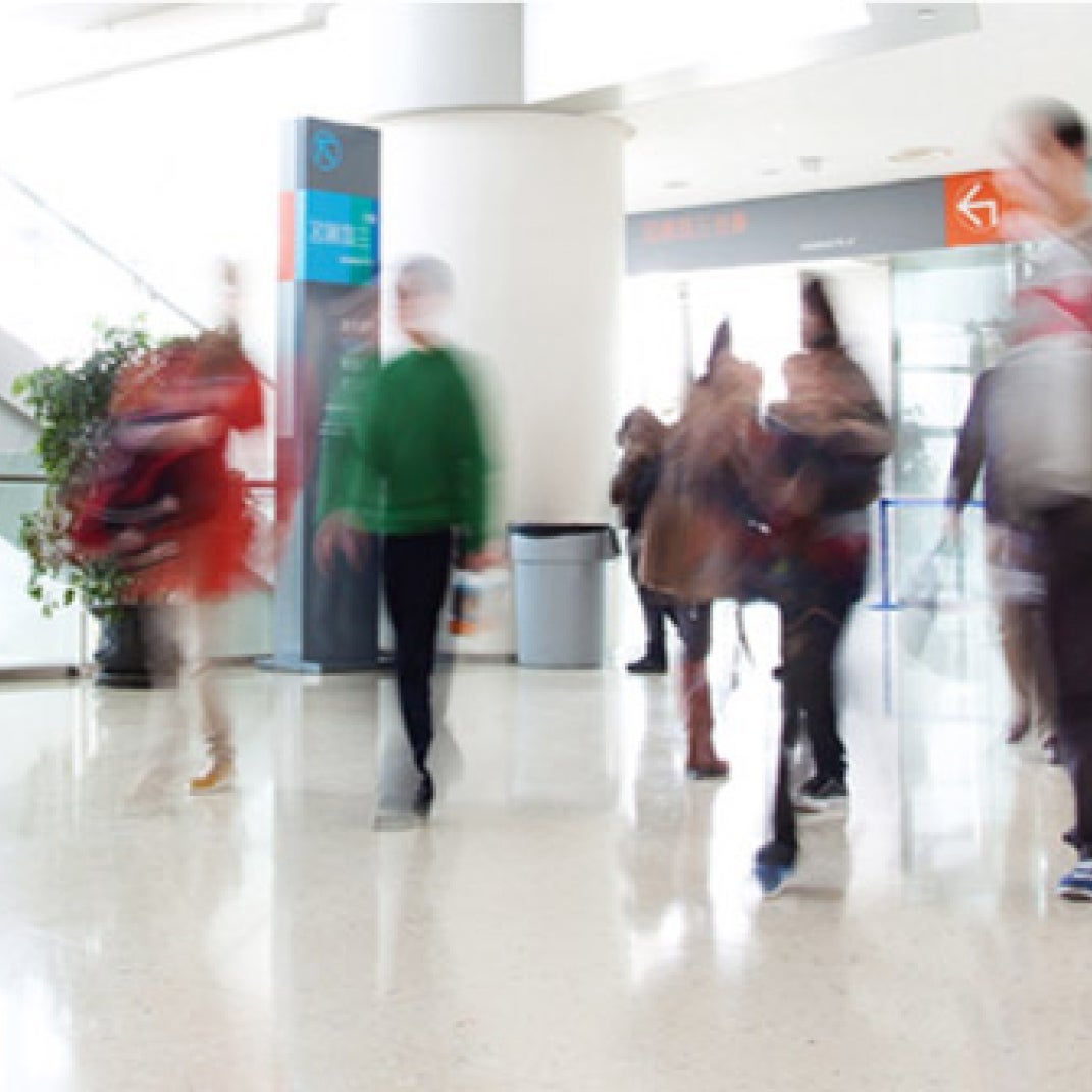 Blurry image of people walking inside of a building.